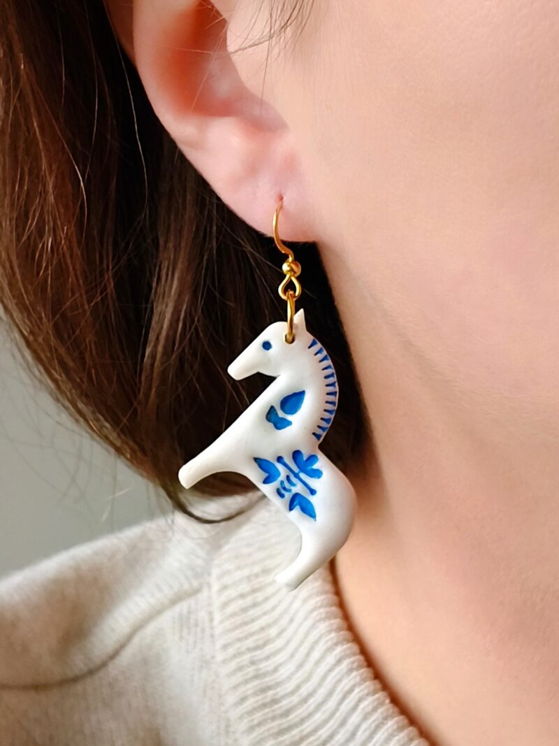 Kolczyki z białym koniem i niebieskimi detalami w rustykalnym stylu, artystyczna biżuteria z motywem zwierząt