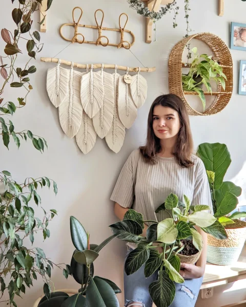 Makrama z piórami w kolorze ecru na ścianie. Wyjątkowa ręcznie robiona dekoracja w stylu boho