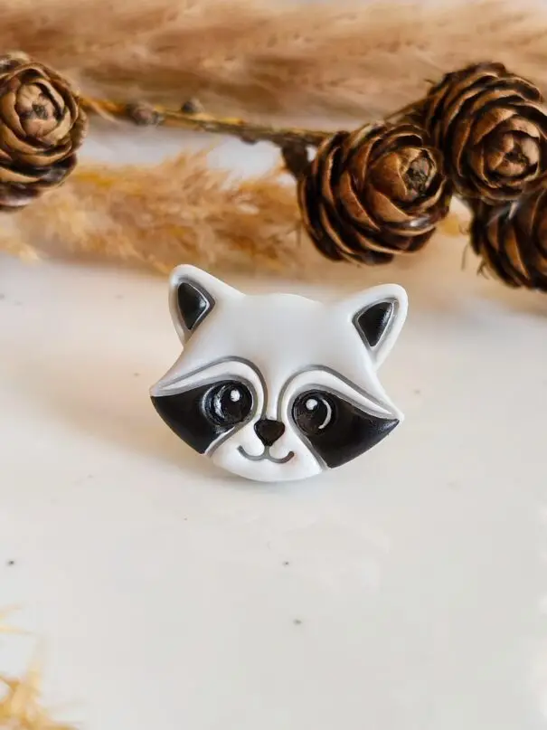 słodki pin szop ręcznie robiony super pomysł na prezent dla osoby kochającej naturę