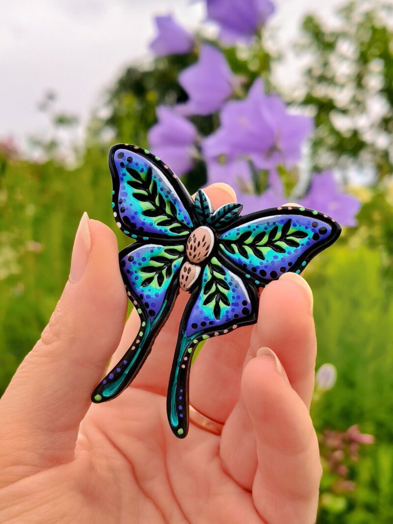 Kolorowy pin z motylem w stylu fantasy w niebiesko-zielonych barwach. Magiczny klimat podkreśla baśniowy charakter przypinki. Idealny dodatek dla fanów fantasy (1)